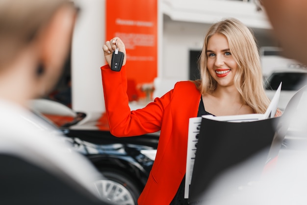 car-dealer-showing-key-her-hand-wide-smiling-closeup_2221-3456